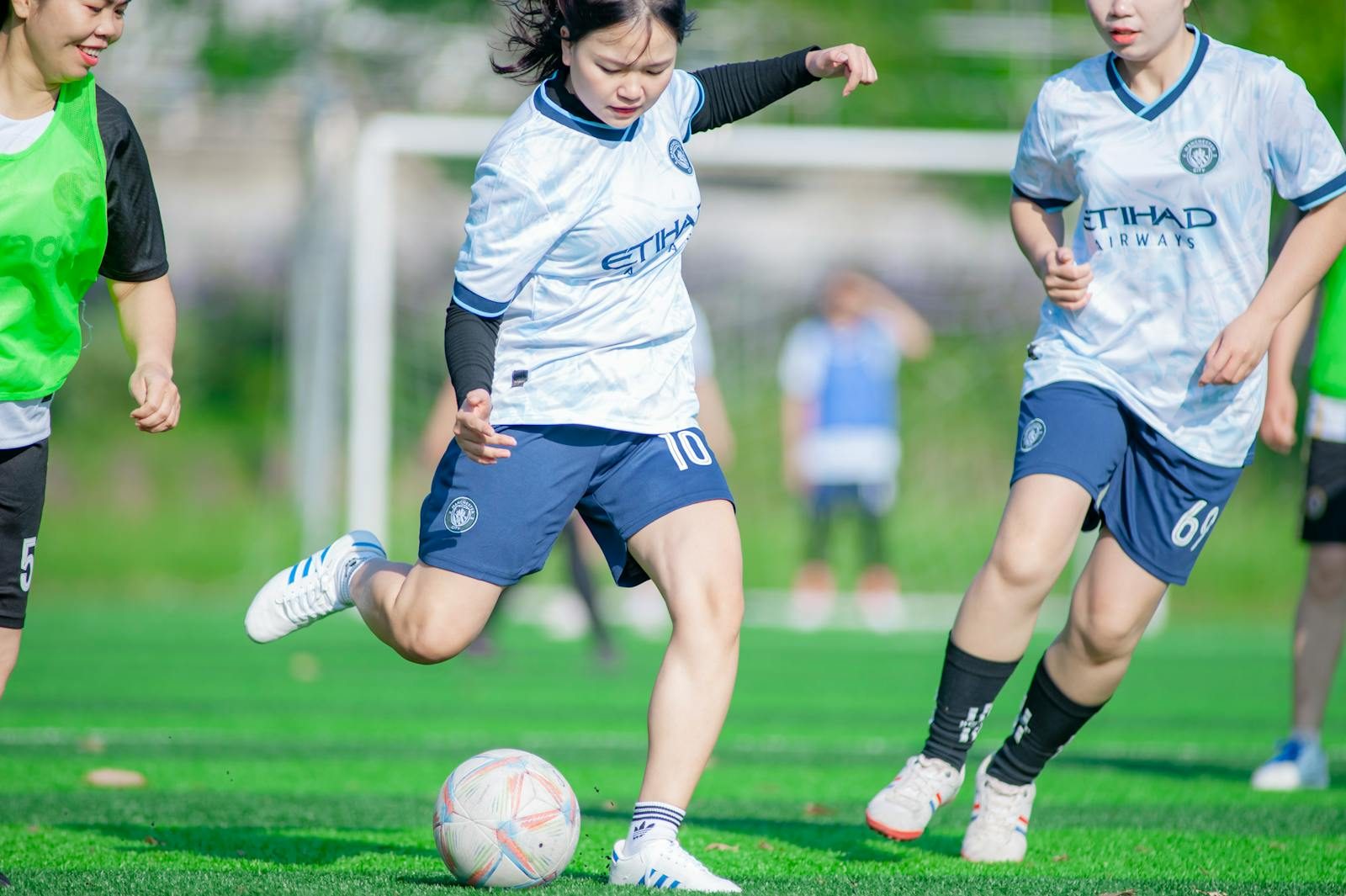 Female soccer players in action during a match in Hanoi, showcasing athleticism and teamwork.